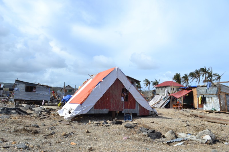 Two kids peer out of their makeshift home built from corrugated metal scavenged from debris left by the typhoon. PHOTO BY KRISTINE SABILLO/INQUIRER.net