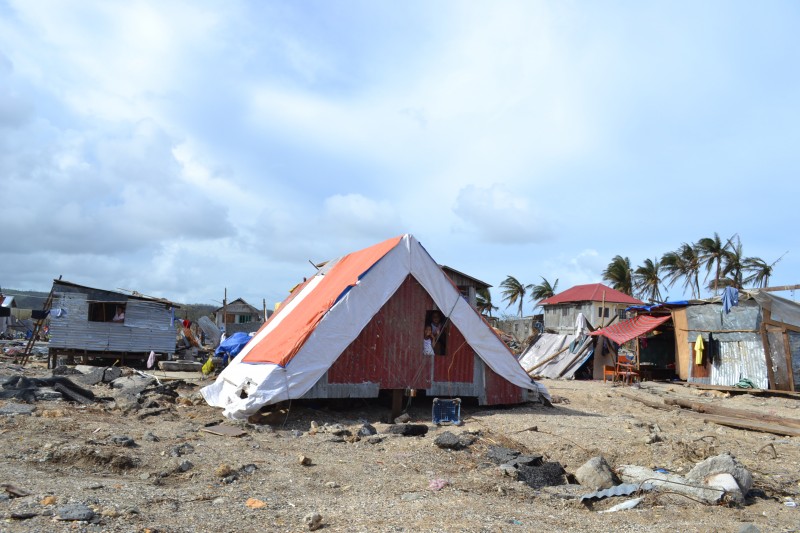 Two kids peer out of their makeshift home built from corrugated metal scavenged from debris left by the typhoon. PHOTO BY KRISTINE SABILLO/INQUIRER.net