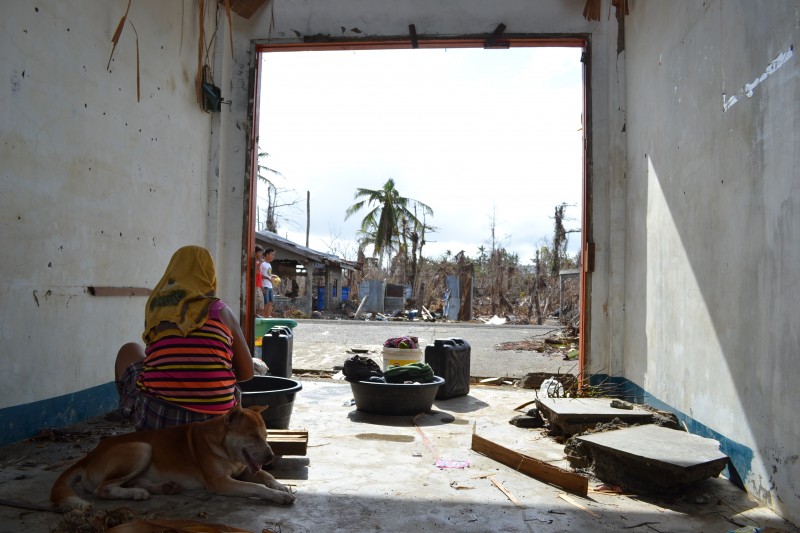 A woman does her laundry under the shelter of an abandoned public market. She stares at the lot across the road where her house once stood. PHOTO BY KRISTINE SABILLO/INQUIRER.net