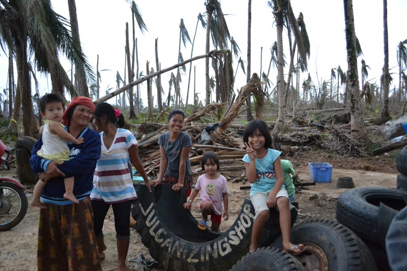 Typhoon survivors smile for the camera despite their houses being damaged. PHOTO BY KRISTINE SABILLO/INQUIRER.net