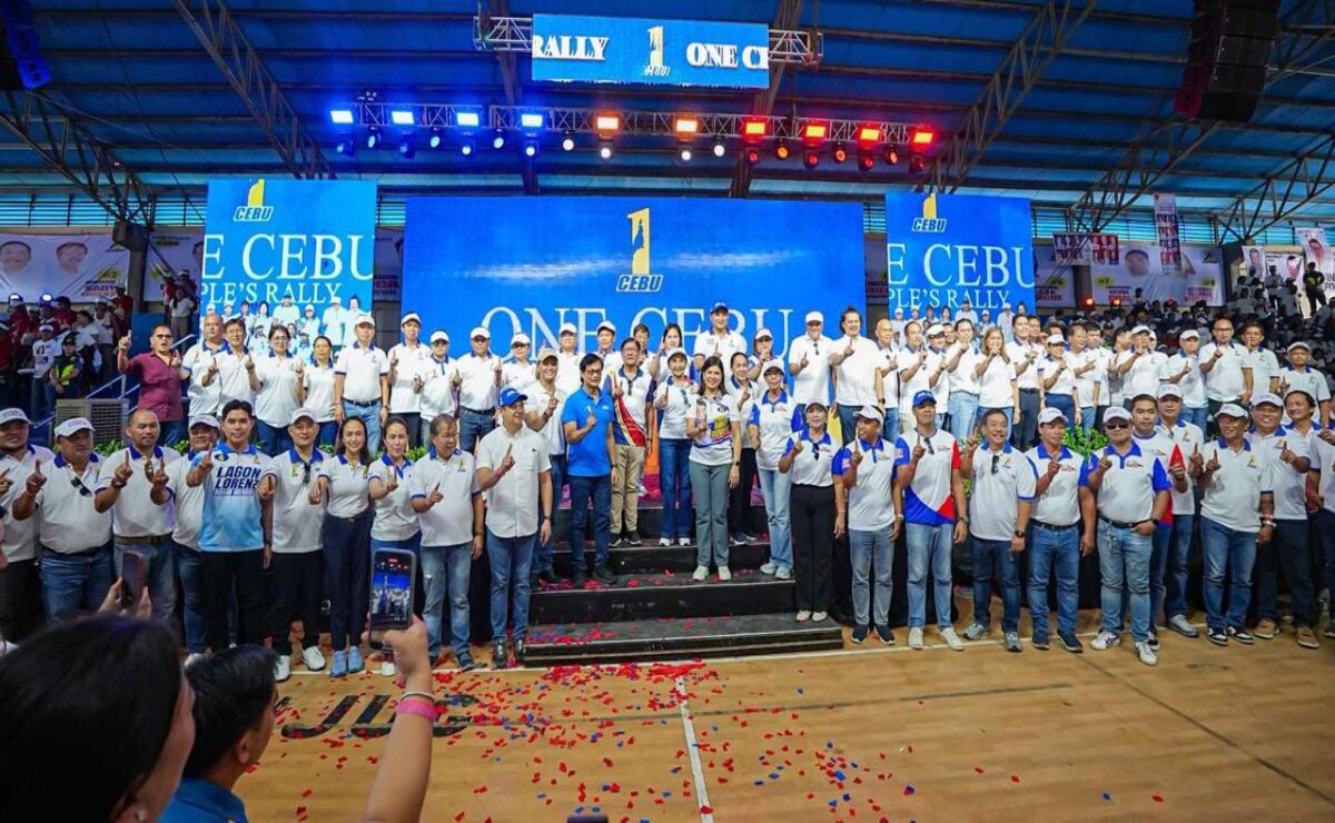 Supporters hold posters as they listen to Benhur Abalos at Cebu rally