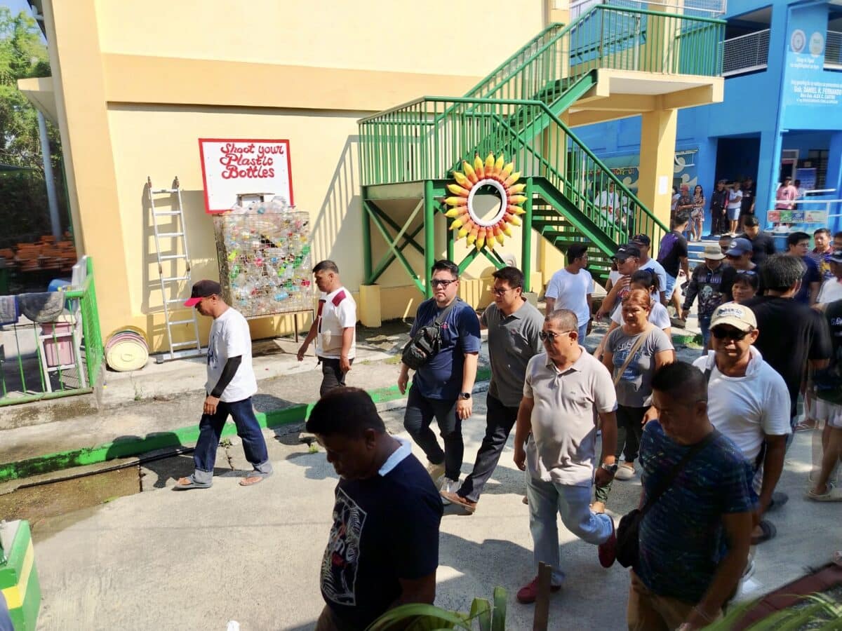 Mayoral candidate and former Bulakan town mayor Patrick Meneses (center, in gray shirt) arrives at Bambang Elementary School shortly after 2 p.m. to cast his vote on Monday, despite the ongoing search for his missing mother. (Photo by Carmela Reyes-Estrope)