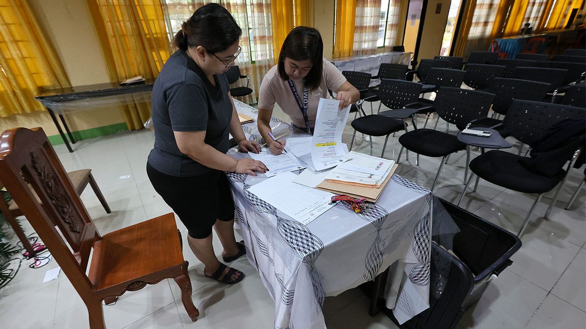FINAL CHECK Leighmae Ciedel De Asis (right), an assistant at the Commission on Elections, turns over election paraphernalia to Nerissa Colasito, supervising support staff of the Department of Education, at Jose Abad Santos Elementary School in Binondo, Manila, amid final preparations on Sunday for the midterm elections. GRIG C. MONTEGRANDE