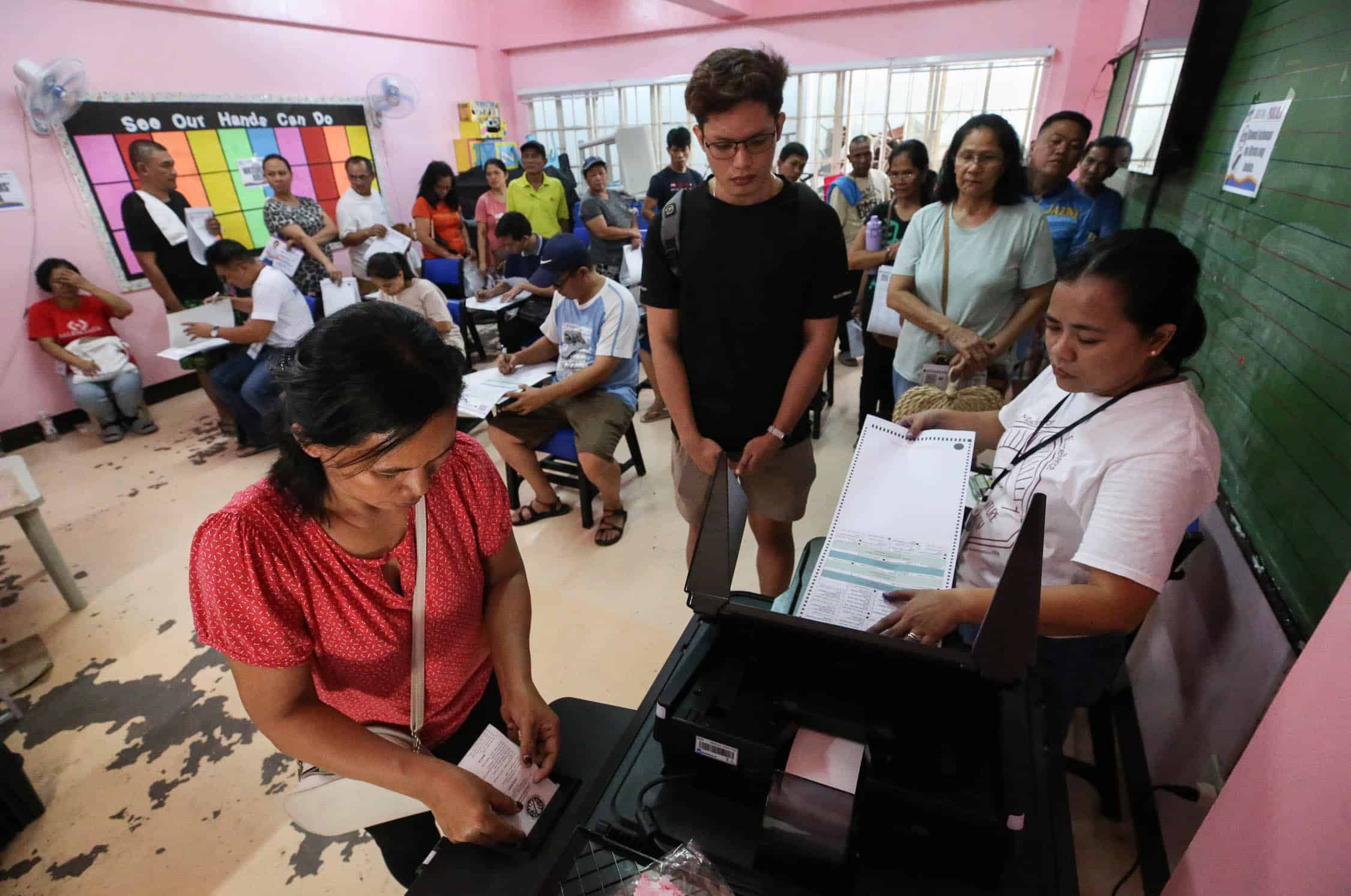 MAY 12, 2025 Voters casting their ballots in Nagpayong Elementary School, Barangay Pinagbuhatan, 2nd District, Pasig City during the May 12, 2025 National and Local Elections. This machine had to be opened several times by the EB chair as it rejected some forms or took a long time to read. The school topped the Comelec list of Voting Centers nationwide with the highest number of registered voters having a total number of 47,249. INQUIRER PHOTO/LYN RILLON