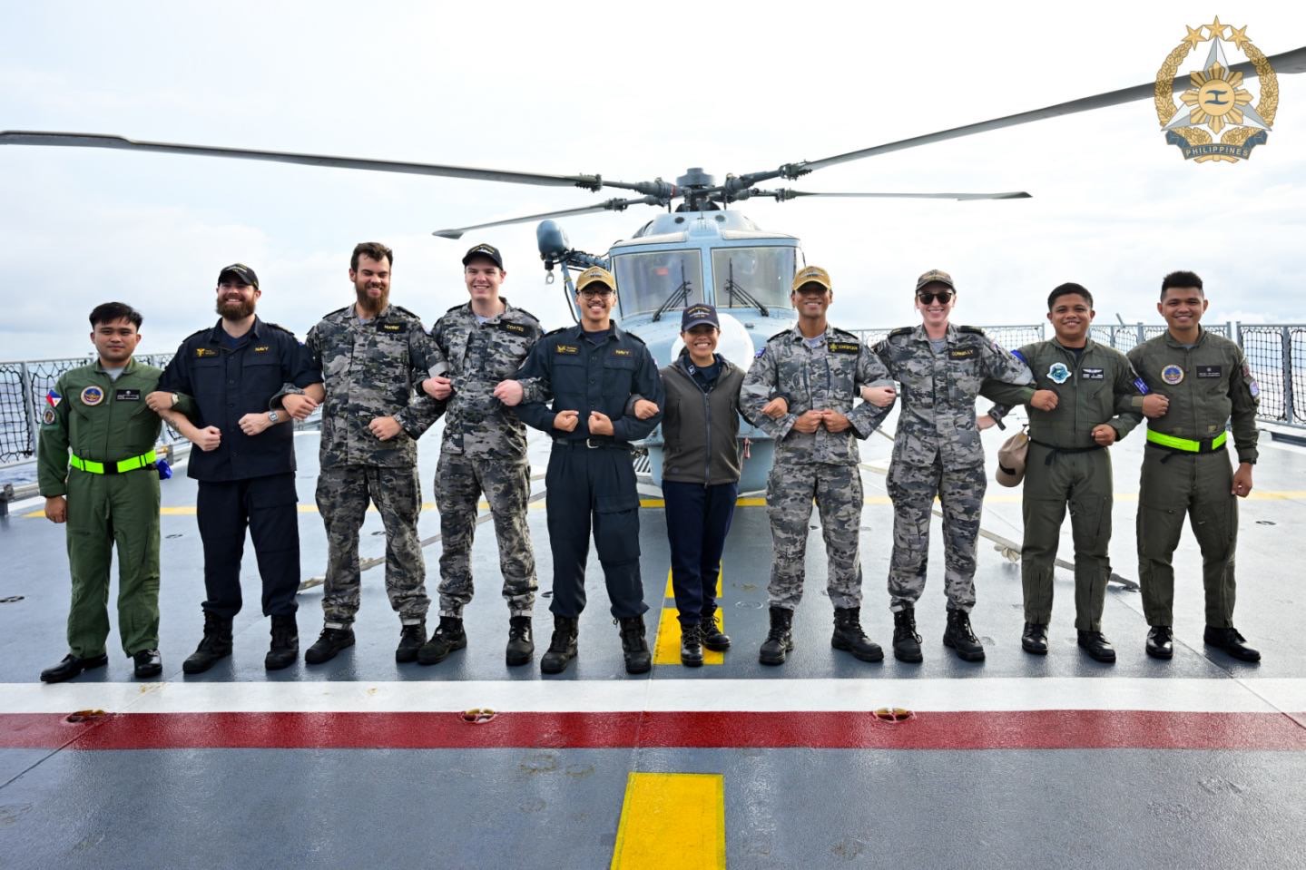 Philippine, New Zealand and Australian personnel aboard BRP Jose Rizal (FF150) link arms in a show of camaraderie and maritime cooperation. (Photo by Edward Bungubung)