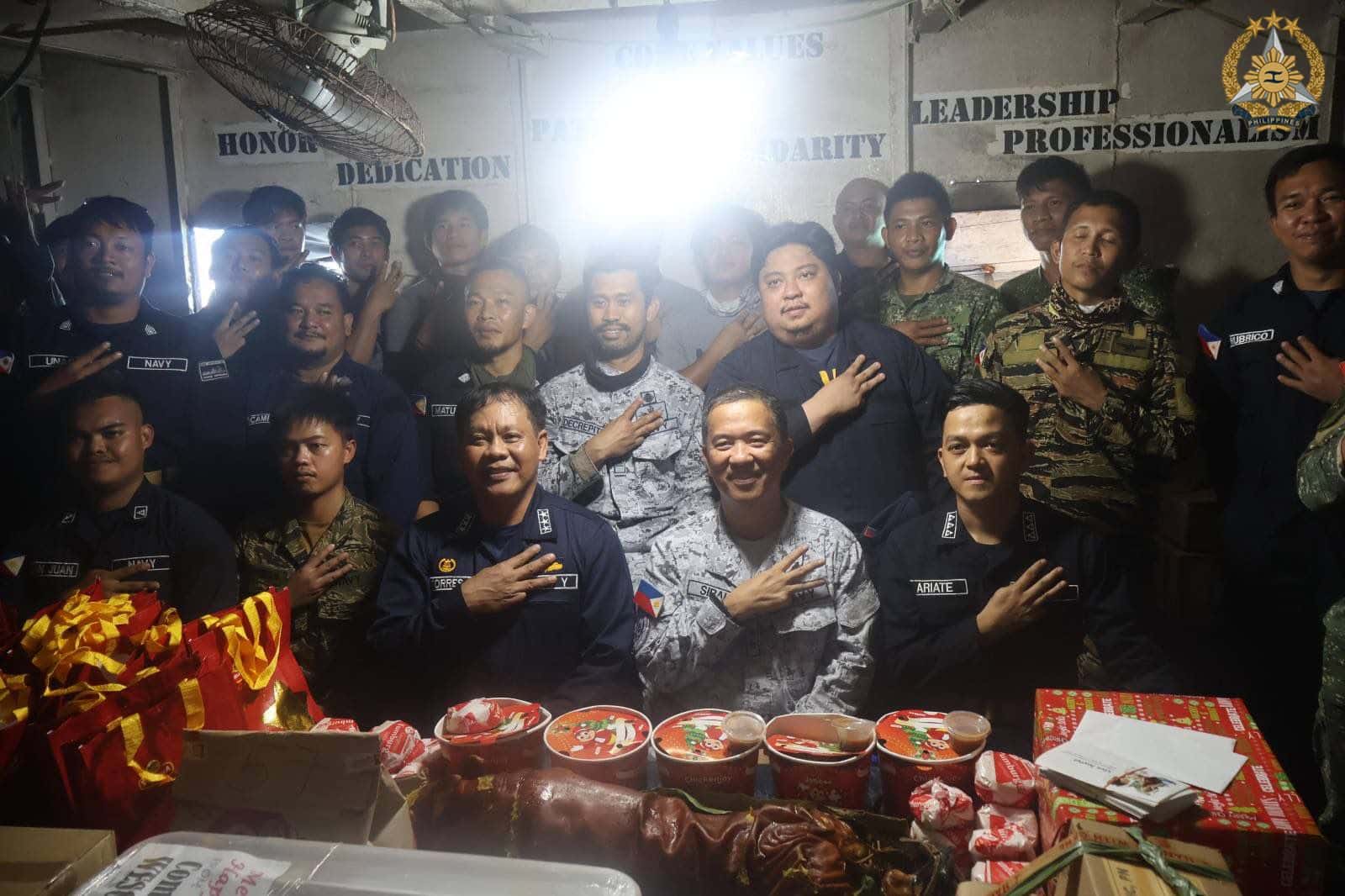 Troops aboard BRP Sierra Madre gets treated with lechon on Dec. 23, 2025. PHOTO FROM AFP